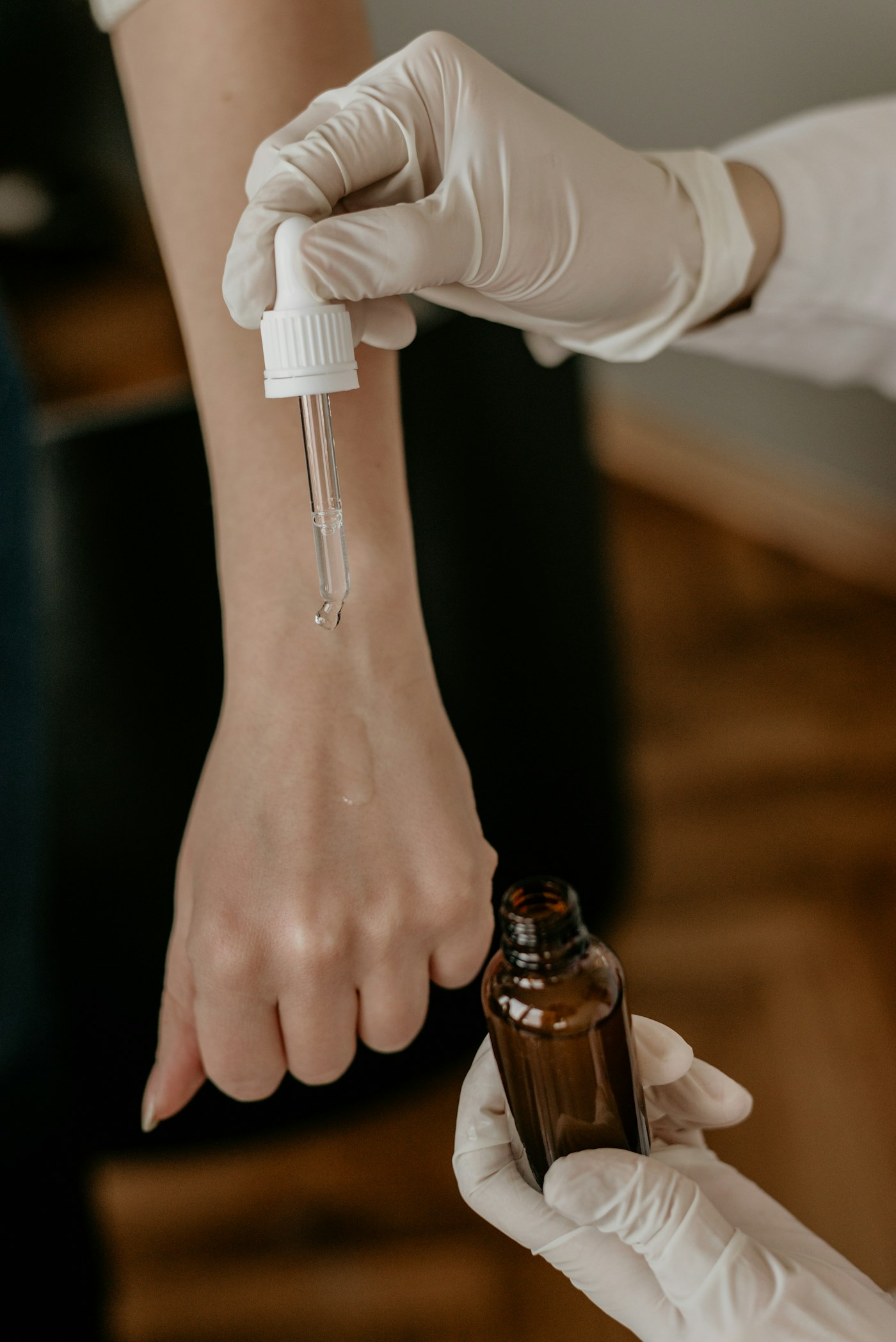 Mâini cu mănuși medicale aplicând o soluție